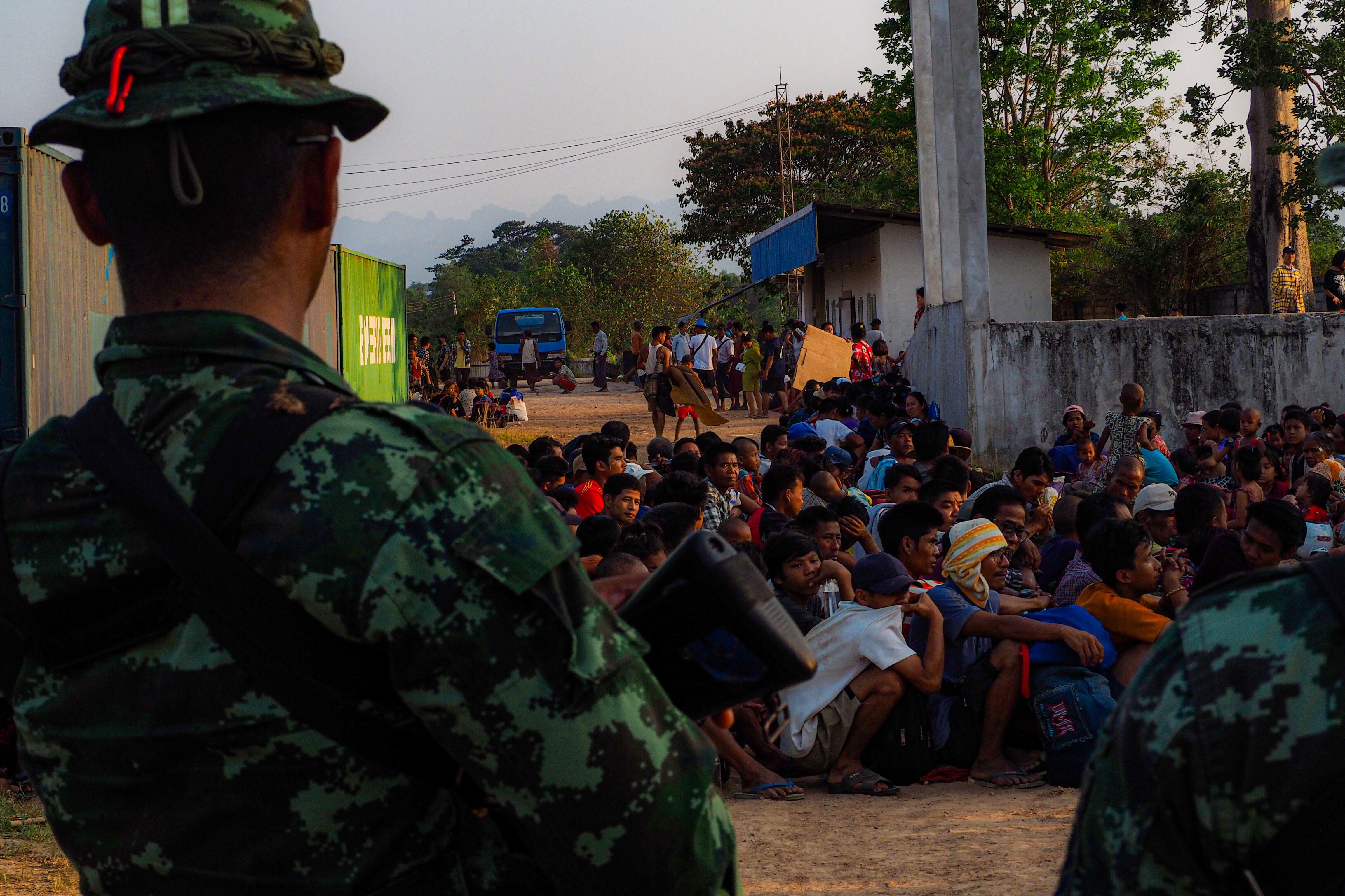 Thai soldiers watch over Myanmar refugees who fled fighting around Myawaddy, 12 April 2024. (Photo: Alamy)